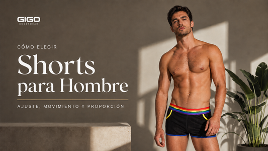 Modelo masculino usando short negro Gigo con pretina arcoíris, detalles amarillos y borde azul, en una portada editorial sobre cómo elegir shorts para hombre según ajuste, movimiento y proporción.