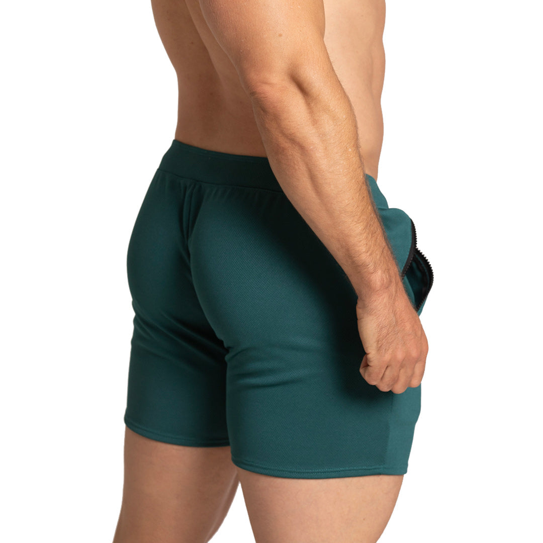 Vista lateral de short verde Gigo para hombre mostrando largo, caída de tela y ajuste favorecedor en glúteos y piernas